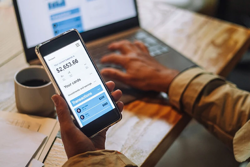 A client on their laptop and mobile phone logging into digital banking